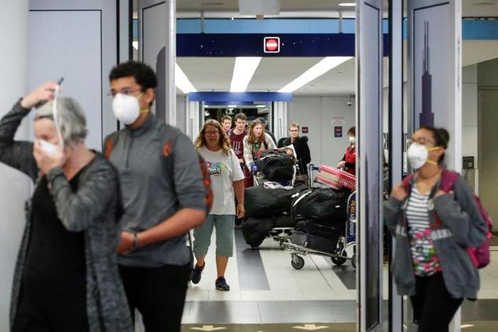 Travelers arrive at the international terminal of O'Hare Airport in Chicago on March 15, 2020