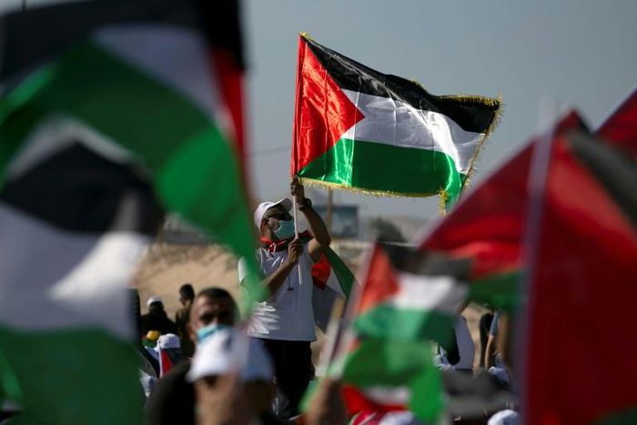 Palestinians wearing masks attend a rally to protest against Israel's plan to annex parts of the occupied West Bank, in Jericho on June 22