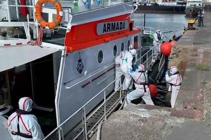 Medics help a sick passenger from an Australian liner off a Uruguay navy launch in Montevideo, on April 3, 2020