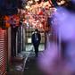 A man wearing a face mask walks along Omoide Yokocho in Tokyo