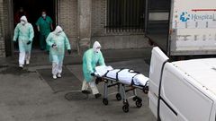 A health worker carries a body on a stretcher outside Gregorio Maranon hospital in Madrid