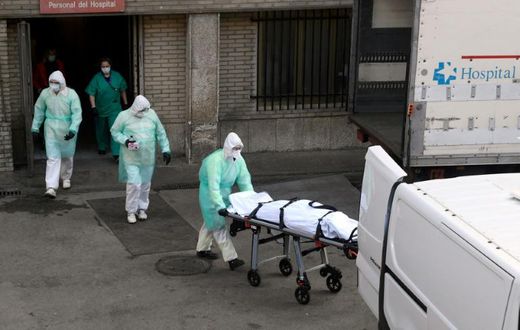 A health worker carries a body on a stretcher outside Gregorio Maranon hospital in Madrid