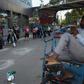A rickshaw puller wearing a face mask watches people standing in a queue in New Delhi on April 8. Officials have now made wearing a mask in the Indian capital compulsory