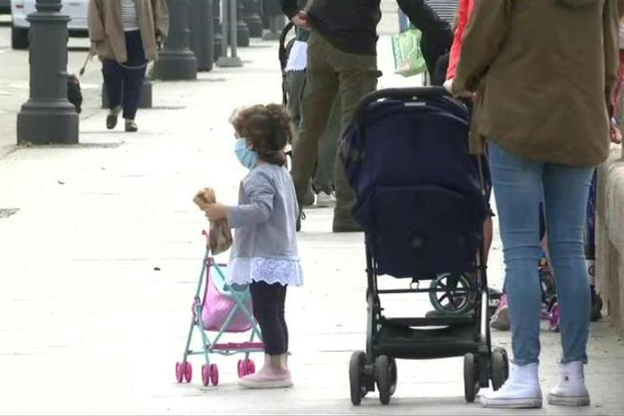 Children in Madrid enjoy the sunshine with their parents, as they are allowed outside on Sunday for the first time in six weeks