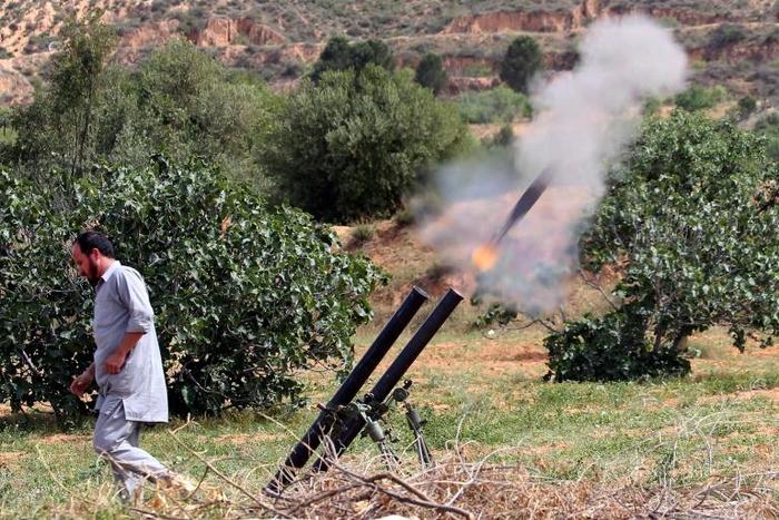 A fighter with Libya's UN-recognised Government of National Accord (GNA) fires rockets towards the city of Tarhuna, southwest of the capital Tripoli, held by the forces of the strongman Khalifa Haftar