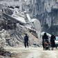 Syrian civilians walk thorugh the former rebel-held town of Harasta in Eastern Ghouta on March 30, 2018, a week after regime forces retook the town