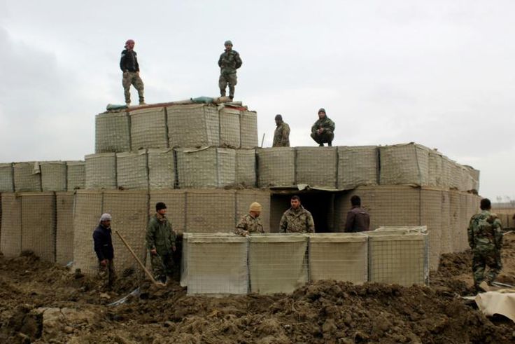 Afghan security forces stand guard at an outpost in Kunduz Province
