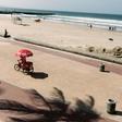 An optimistic ice cream vendor cycles along a deserted beach in Durban, South Africa. Tourism is one of the key African sectors hit by the coronavirus pandemic
