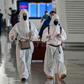 Passengers in protective gear walk through Tianhe Airport after it was reopened in Wuhan in China's central Hubei province