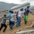 Relatives carry the coffin of a suspected COVID-19 victim in the outskirts of Lima, Peru