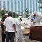 Workers wrap with plastic a coffin with the remains of a person who died from the coronavirus, COVID-19 in Guayaquil, Ecuador