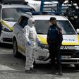A policeman talks to a member of the Spanish Army's Military Emergency Unit (UME) wearing a protective suit outside the Palacio de Hielo shopping mall where an ice rink was turned into a temporary morgue on March 24, 2020 in Madrid