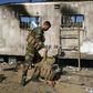 An Iraqi fighter with the Hashed al-Shaabi force inspects the site of the Islamic State group attack in Mukaishefah, about 180 km (110 miles) north of Baghdad, in May 2020