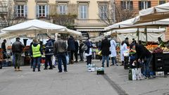 A municipal policeman checks people are keeping their distance at the fruit and vegetable market in piazza San Cosimato, in the Rome district district of Trastevere