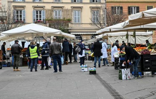 A municipal policeman checks people are keeping their distance at the fruit and vegetable market in piazza San Cosimato, in the Rome district district of Trastevere