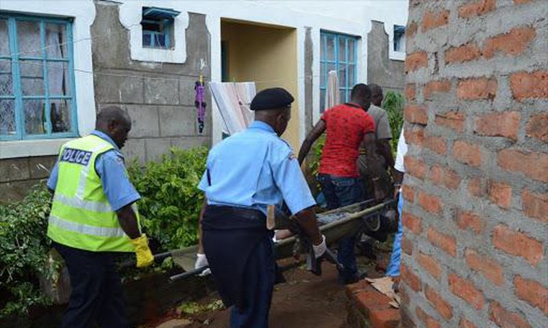 File image of police officers carrying a body. Police officer dies while having breakfast at girlfriend's house in Tena, Umoja Estate