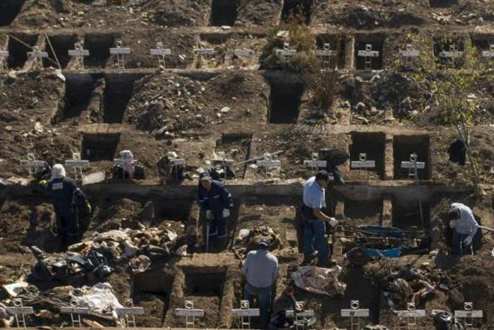 Workers dig graves in Santiago's General Cemetery after health authorities ordered them to prepare for a possible surge in deaths from COVID-19