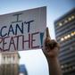 A demonstrator raises a sign during a protest against the death of George Floyd who died on May 25 in Minneapolis whilst in police custody, along a street in Oakland, California on June 3