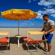 A beach manager spaces out sunbeds on the seafront of Cesenatico on the Adriatic coast
