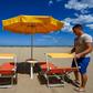 A beach manager spaces out sunbeds on the seafront of Cesenatico on the Adriatic coast