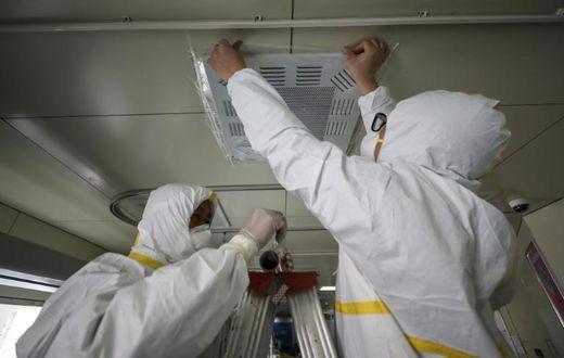 Medical staff seal a vent in what used to be an isolation ward for patients infected by the COVID-19 coronavirus at a hospital in Wuhan, China