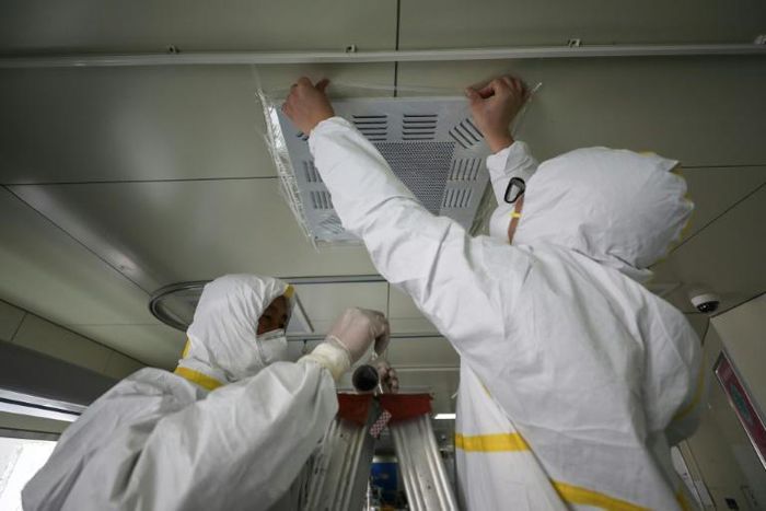 Medical staff seal a vent in what used to be an isolation ward for patients infected by the COVID-19 coronavirus at a hospital in Wuhan, China