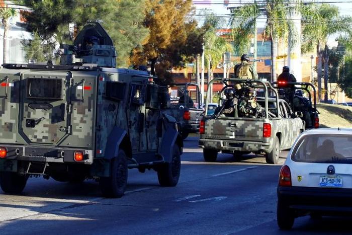 Mexican soldiers with an armoured car patrol the streets during a 2014 operation against the Jalisco Next Generation narcotics cartel