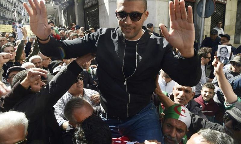Algerian protesters carry journalist Khaled Drareni, who was arrested while covering an anti-government protest and was accused of "inciting an unarmed gathering and damaging national integrity," on their shoulders on March 6, 2020 in Algiers
