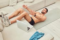 Shirtless young man working out in living room