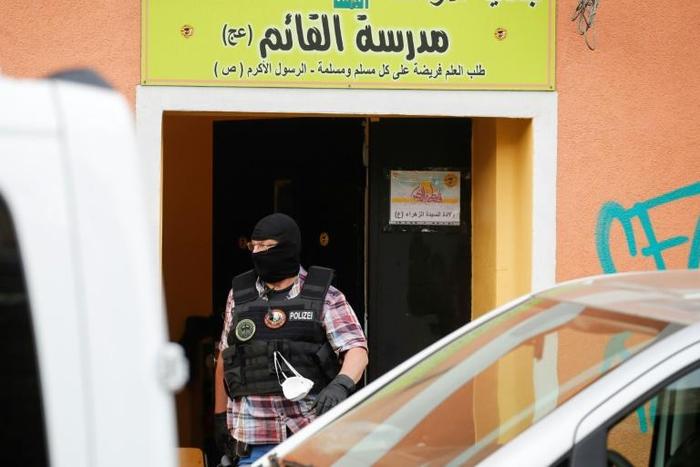 A police officer walks out of Al-Irschad Mosque during a raid in Berlin, as dozens of police and special forces stormed mosques and associations linked to Hezbollah in Bremen, Berlin, Dortmund and Muenster early Thursday.