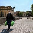 People wearing face masks carry their groceries across the Ponte Sisto bridge on April 24, 2020 in Rome, during the country's lockdown aimed at stopping the spread of the COVID-19 pandemic, caused by the novel coronavirus