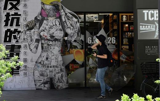 A woman in Taipei walks past a billboard promoting democracy for Hong Kong