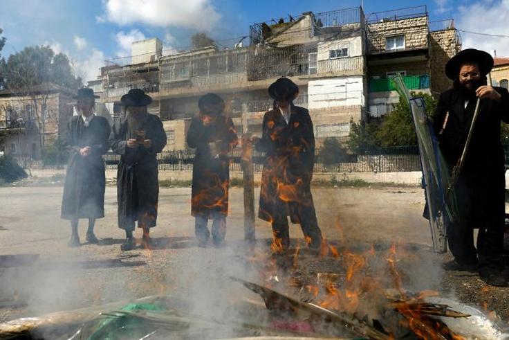 Jewish men burn food with leavening agents ahead of the start of Passover, in the the ultra-Orthodox Mea Shearim neighbourhood of Jerusalem