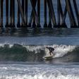 Surfers catch a wave in Huntington Beach, California on May 2