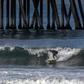 Surfers catch a wave in Huntington Beach, California on May 2