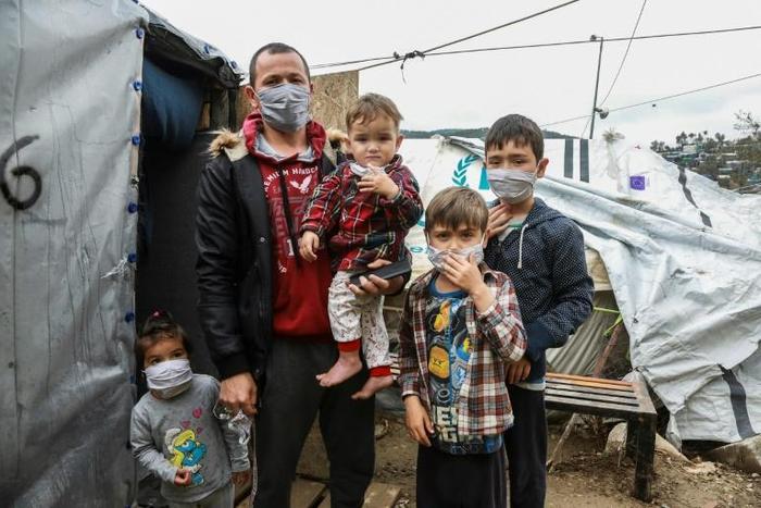 A migrant family wearing handmade protective face masks in the camp of Moria on the Greek island of Lesbos