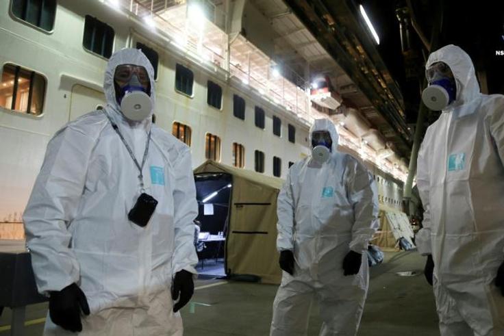Police officers in protective gear prepare to board the coronavirus-stricken Ruby Princess cruise ship and seize its black box at Port Kembla, Australia