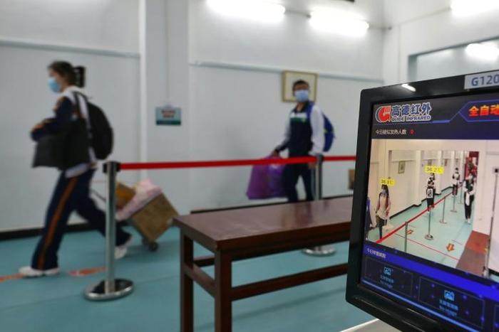 School rules: students must stay a metre apart and walk past thermal scanners as they arrive