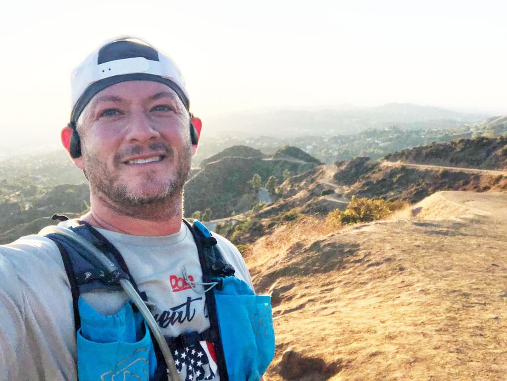 man taking selfie in front of landscape
