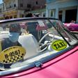 Workers of a private taxi company disinfect old American cars wearing face masks as a preventive measure against the spread of the new coronavirus