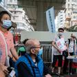 People stand at a booth where passersby can give their signatures in support of a new security law in Hong Kong