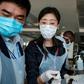 Chinese embassy officials help screen incoming passengers for the new coronavirus as they arrive at Entebbe Airport in Uganda on March 3, 2020