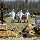 Cemetery workers in protective gear bury a coronavirus victim at a cemetery on the outskirts of Saint Petersburg. Russia has reported a remarkably low death toll but critics have cast doubt on the numbers