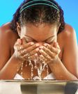 African woman washing her face