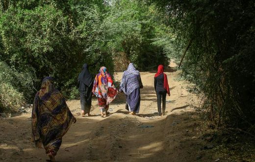 Sudanese women walk in the capital Khartoum's district of Jureif Ghar
