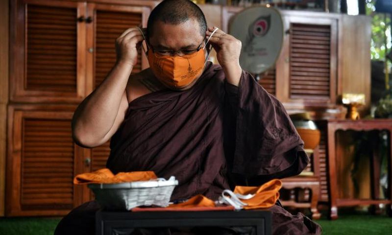 Thai monks are weaving recycled synthetic fibres with cotton into piles of saffron-coloured masks