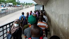 People walk on a pedestrian bridge without adhering to social distancing in Dar es Salaam, Tanzania, in April 2020