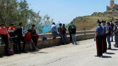 Police are shown checking and detaining some of the migrants, who left the beach in small groups