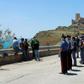 Police are shown checking and detaining some of the migrants, who left the beach in small groups