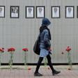A woman walks past a makeshift memorial for Russian medical workers who have died from the COVID-19 disease, set up outside the local health department in Saint Petersburg. More than 70 have died so far.
